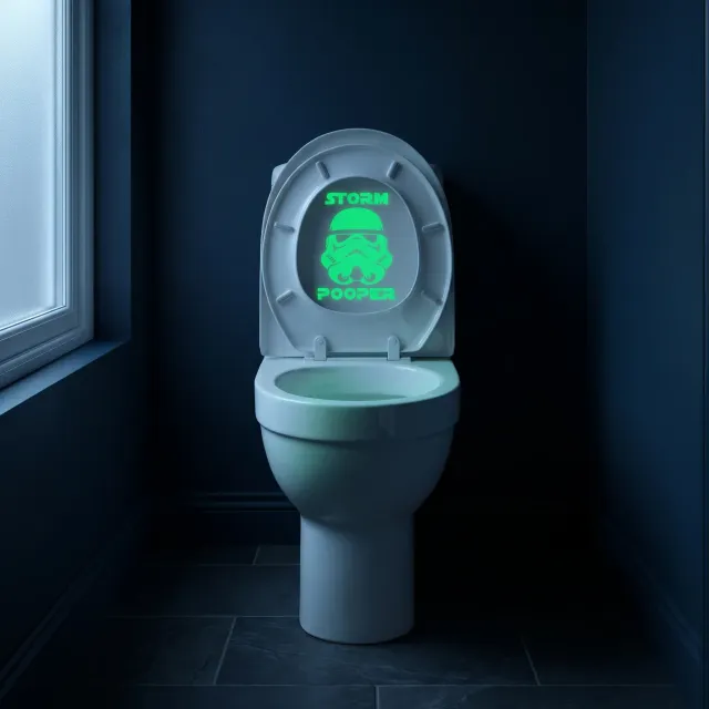 Storm Pooper decal glowing green on a raised toilet lid in a dark midnight blue bathroom lit by moonlight